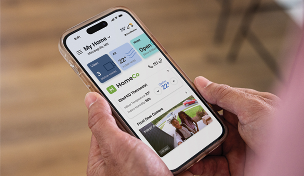 Person holding a smartphone with a home automation app displayed